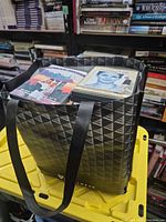 Bag on yellow bin showing top DVDs and surrounding books