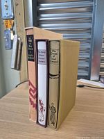 Spines of all three Folio Society cloth-bound books standing upright