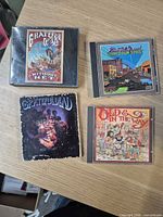 Four CD jewel cases arranged on table showing front cover art