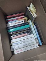 Box of books showing spines including Discipline & Punish, assorted Foucault titles, three white hardcovers