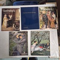 Five auction catalogs arranged on table