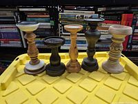 Front view of five wooden candlestick holders lined up