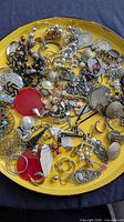 Full view of yellow plate containing assorted earrings