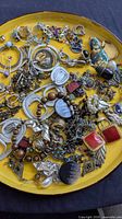 Overview of assorted earrings on yellow plate