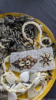 Overview of assorted jewellery on yellow plate