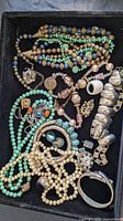 Overview of full lot showing necklaces, bracelets, rings and brooch in tray