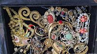 Overview of assorted costume jewellery in box