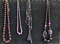 Four necklaces displayed side by side showing overall styles and colors