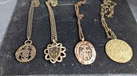 Four necklaces laid out showing pendant styles and chains
