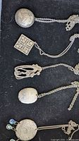 All five pendant necklaces laid out to show shapes and motifs