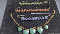 All four necklaces laid out for full view of styles and colors