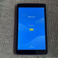 Tablet powered on displaying welcome screen