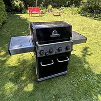 Front view of Broil King Baron 440 grill with side shelves and control panel