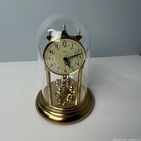 Full view of Konig anniversary clock under glass dome