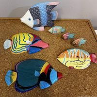 All seven wooden fish arranged on cork surface
