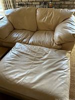 Loveseat with ottoman positioned in front, showing upholstery and cushion style