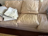 Full view of sofa with cushions, folded blankets shown