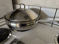 Pan with lid on stovetop showing exterior and handle