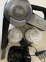 Vacuum, two sealed filters, charging base and adapter front view