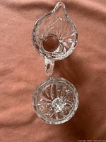 Top view of creamer pitcher and sugar bowl lid showing starburst pattern and clarity