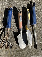 All four garden hand tools laid out side by side