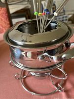Fondue pot on stand with forks inserted