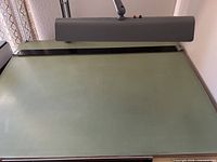 Top view showing full pale green laminate surface and attached lamp and straightedge