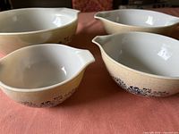 All four beige speckled Pyrex bowls with blue floral pattern, nested arrangement showing pour spouts