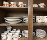 Cabinet view showing mugs, dinner plates, salad plates, sugar bowl, creamer, and cups