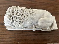 Top view of cast resin sleeping lion sculpture showing mane and overall form