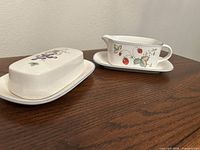 Butter dish and gravy boat set on table