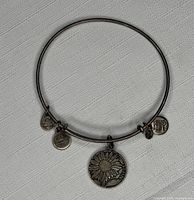 Top-down view of bracelet showing all four charms and silver-tone finish