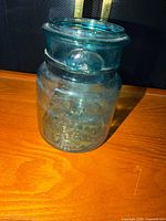 Full view of blue-green glass jar with lid