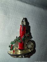 Front view of gold-tone Christmas candle brooch showing enamel colors and rhinestones