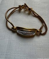 Overall view of bracelet laid flat showing double snake chains, bar design, clasp