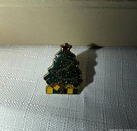 Front view of enamel Christmas tree pin showing design and colours