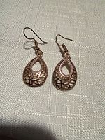 Front view of both teardrop gold tone earrings showing filigree pattern
