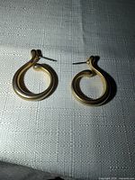 Front view of both gold tone teardrop hoop earrings