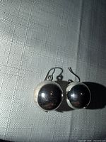 Front view of both silver-tone ball earrings showing size, shape and hooks