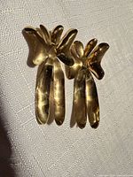 front view of gold-tone abstract bow earrings