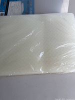 Stack of five white plastic cutting boards in shrink wrap with IKEA label visible