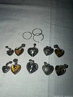 All eight heart charms and three hoop rings displayed on table