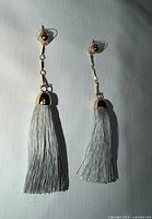 Front view of both gray tassel earrings showing full length and goldtone caps