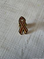 front view of red and white striped ribbon pin