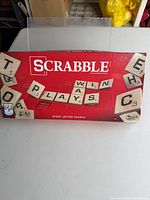 Front of Scrabble game box with logo and tile graphic