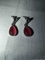 Front view of both earrings showing silver-tone setting and pink teardrop crystals