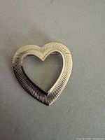 Front view of gold-tone open-heart brooch showing ribbed texture