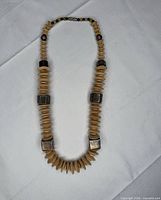 Full view of necklace laid flat showing bead pattern and clasp