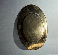 front view of brooch showing oval recessed center and patina