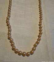 Full view of pearl necklace laid flat showing strand